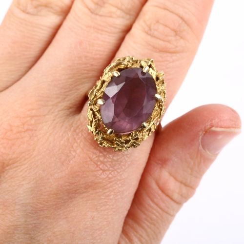 295 - A 1970s 9ct gold amethyst abstract ring, with naturalistic leaf surround and oval mixed-cut amethyst... 