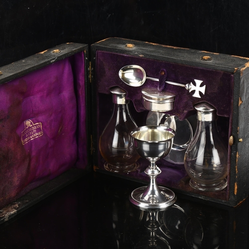 300 - A leather-cased George V church communion set, comprising chalice, paten, wafer pyx, pair of glass c... 