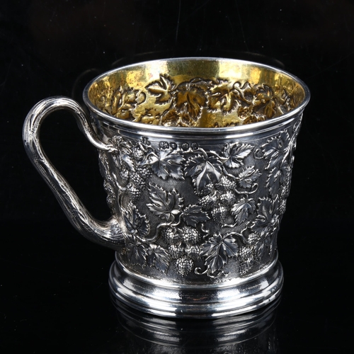 337 - A Victorian silver grapevine mug, relief embossed and chased decoration with vine handle and gilt in... 