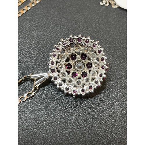 117 - A modern ruby and diamond cluster target pendant necklace, unmarked white gold settings with round-c... 