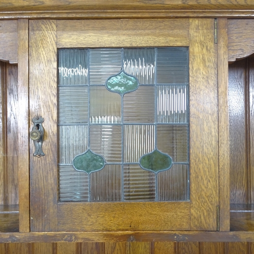 2131 - An early 20th century oak Arts and Crafts 2-section dresser, with single lead-light glazed cupboard ... 