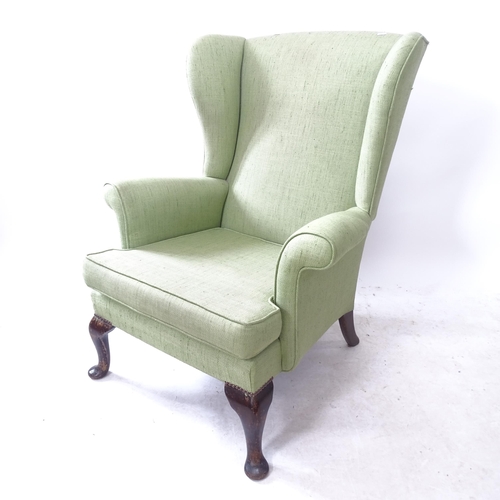 2184 - A 1920s wingback armchair, on mahogany cabriole legs. H - 97cm, Seat H - 41cm, W - 79cm, W between a... 