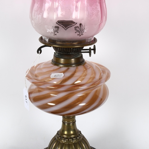 517 - A Victorian embossed brass oil lamp, with coloured glass font, chimney and cranberry glass shade, 54... 