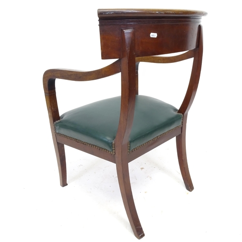 2552 - A Victorian mahogany open-arm desk chair, with green faux leather upholstery