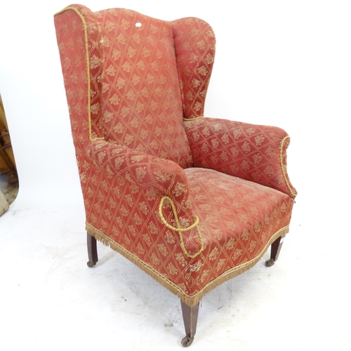 2595 - An Antique upholstered wing-back armchair (A/F)