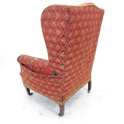 2595 - An Antique upholstered wing-back armchair (A/F)