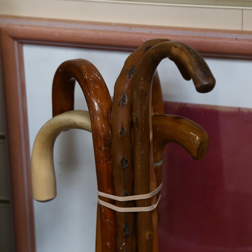 623 - A bundle of walking sticks, in ceramic stick stand with floral decoration