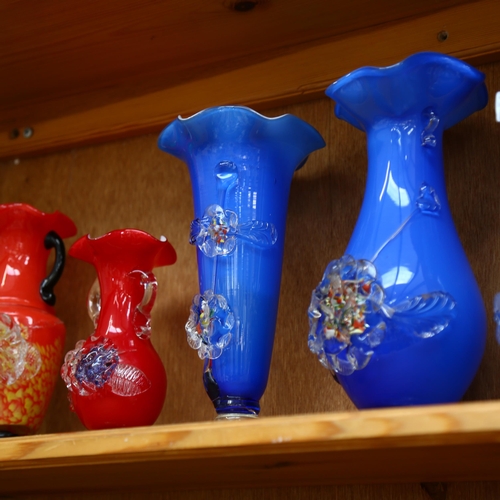 634 - A shelf of colourful 1950s glass vases with applied floral decoration, tallest 25cm