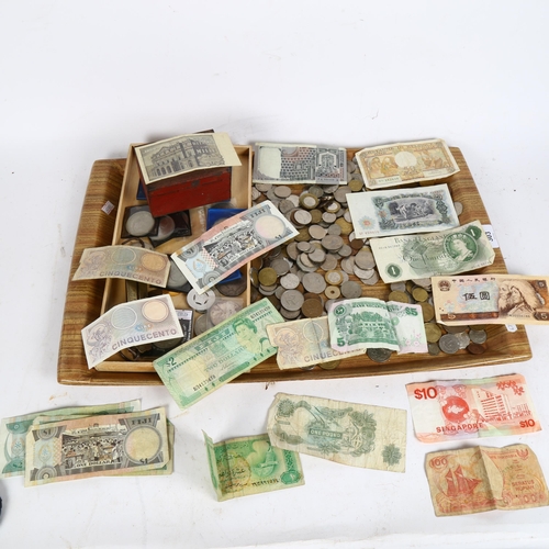 303 - A tray of various foreign coins and banknotes, including an English pound note, Fijian dollars, comm... 