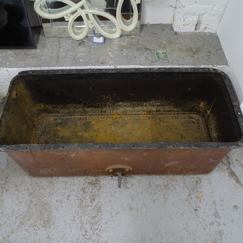 2677 - A large riveted cast-iron trough/tank with tap, L142cm, H55cm, D70cm