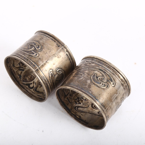 919 - A pair of Art Nouveau Continental silver napkin rings, relief embossed decoration by F Potier, band ... 