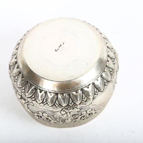 924 - An Indian white metal bowl, with allover engraved and embossed decoration, the central band decorate... 