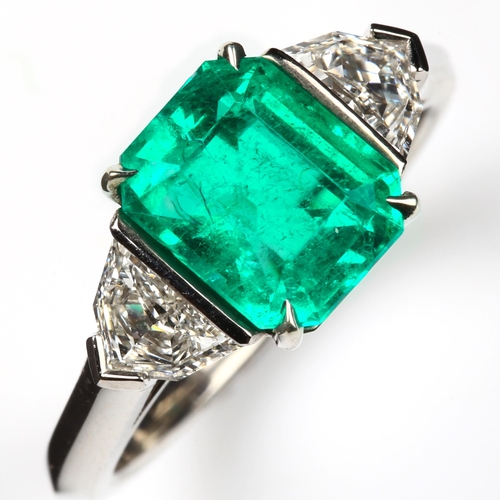 105 - A three stone Colombian emerald and diamond ring, platinum settings with 2.43ct octagonal step-cut e... 