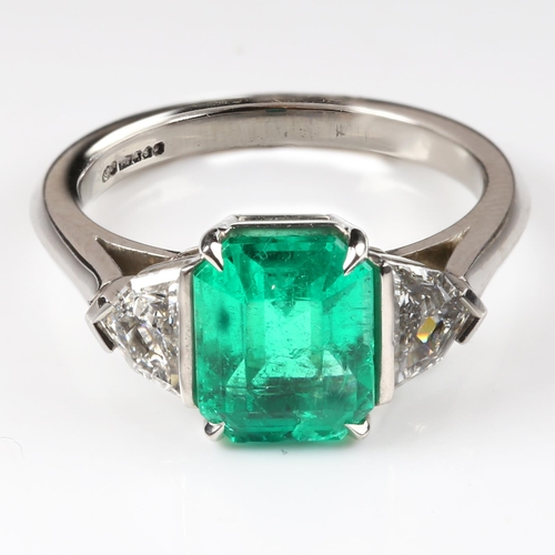 105 - A three stone Colombian emerald and diamond ring, platinum settings with 2.43ct octagonal step-cut e... 