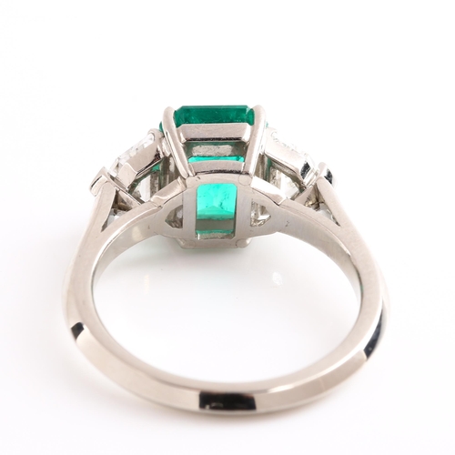 105 - A three stone Colombian emerald and diamond ring, platinum settings with 2.43ct octagonal step-cut e... 