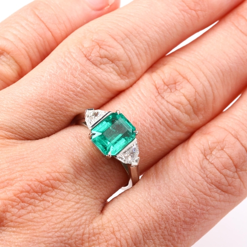 105 - A three stone Colombian emerald and diamond ring, platinum settings with 2.43ct octagonal step-cut e... 