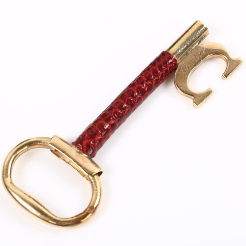 120 - CARTIER - a 9ct gold and red leather key ring fob, signed and numbered 76961, hallmarks London 1978,... 