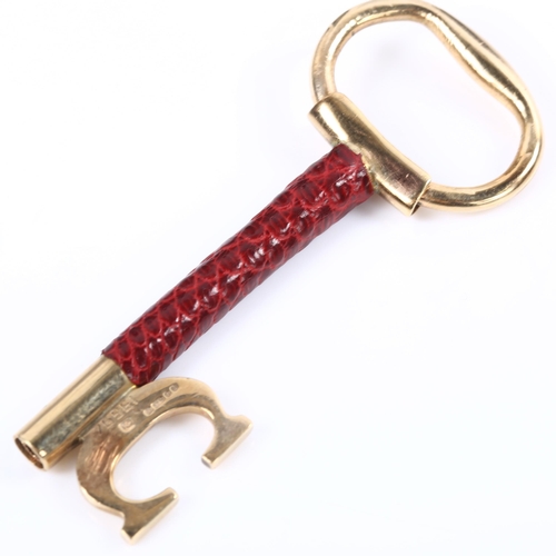 120 - CARTIER - a 9ct gold and red leather key ring fob, signed and numbered 76961, hallmarks London 1978,... 