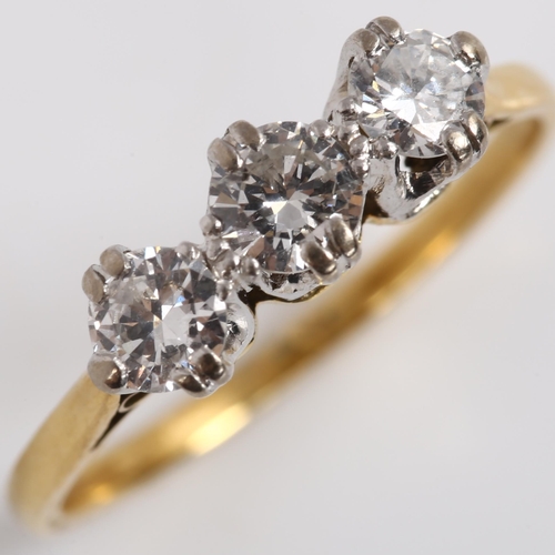 144 - A three stone diamond ring, unmarked gold settings, with modern round brilliant-cut diamonds, total ... 