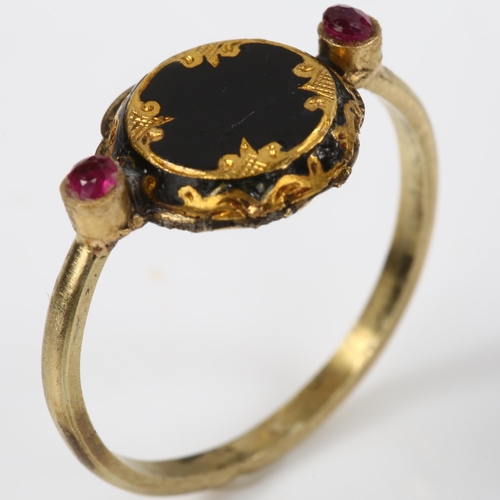 151 - An Antique black enamel and ruby mourning ring, unmarked gold settings with engraved closed-back hea... 