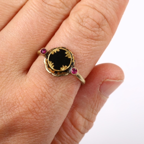 151 - An Antique black enamel and ruby mourning ring, unmarked gold settings with engraved closed-back hea... 