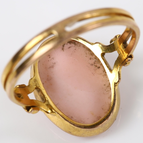 165 - An unmarked gold relief carved pink coral cameo ring, depicting female profile, setting height 16mm,... 