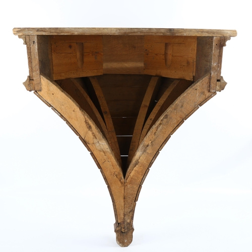 1008 - A large Victorian Gothic oak shelf bracket, with relief carved Gothic tracery frieze, height approx ... 