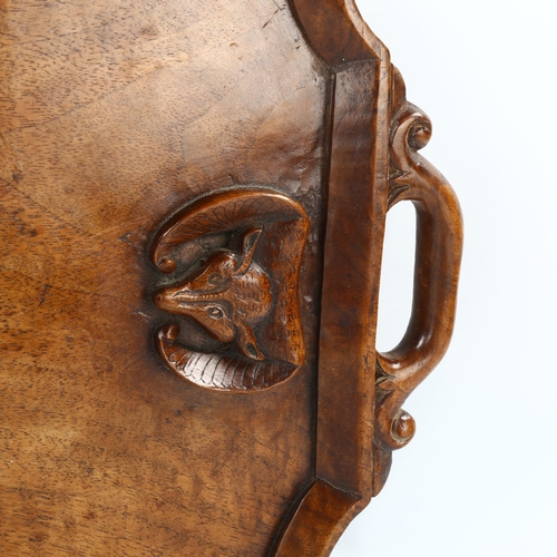 1009 - An Indian hardwood tray with relief carved bats and snakes, in moulded surround, length 60cm