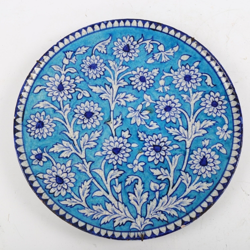 1191 - A 19th century Multan pottery charger, with blue painted floral decoration, diameter 32cm