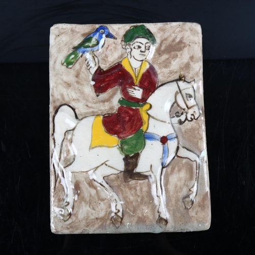 1199 - An Islamic relief moulded and painted pottery tile depicting a huntsman, 19.5cm x 14.5cm