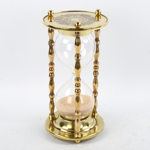 1209 - A large brass and glass sand hour glass, height 24cm, diameter 12cm