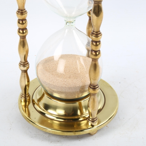 1209 - A large brass and glass sand hour glass, height 24cm, diameter 12cm