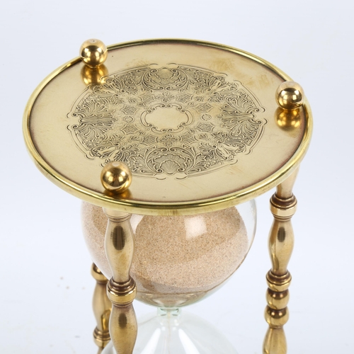 1209 - A large brass and glass sand hour glass, height 24cm, diameter 12cm