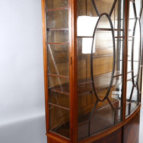 1235 - An Edwardian inlaid mahogany bow-front display cabinet in Sheritan style, with carved cornice and cu... 