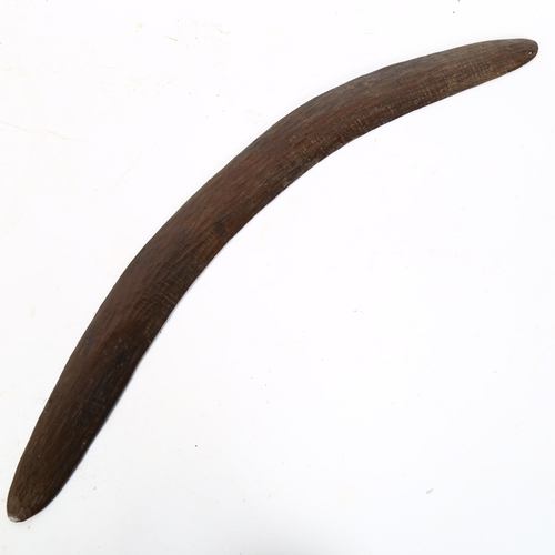 75 - An Australian Aboriginal carved wood boomerang, length 60cm
