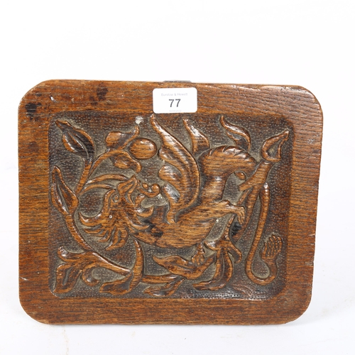 77 - An Arts and Crafts carved oak griffin footstool, with carved side panels, W27cm, H20cm, D22cm