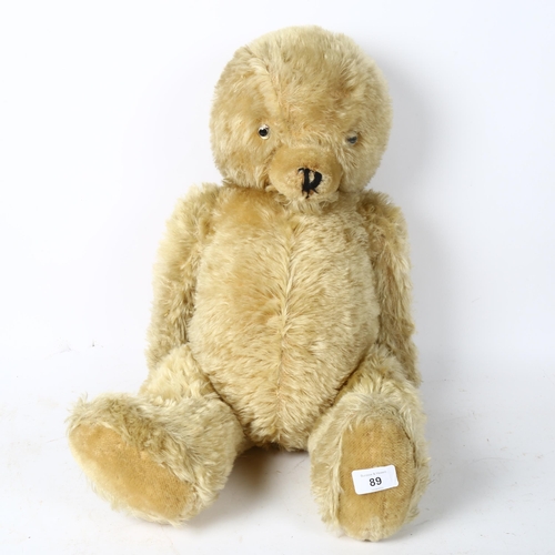 89 - A large straw-filled teddy bear, height 65cm
