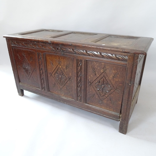 2058 - An Antique panelled oak coffer with carved decoration, on stile legs, 125cm x 67cm x 53cm