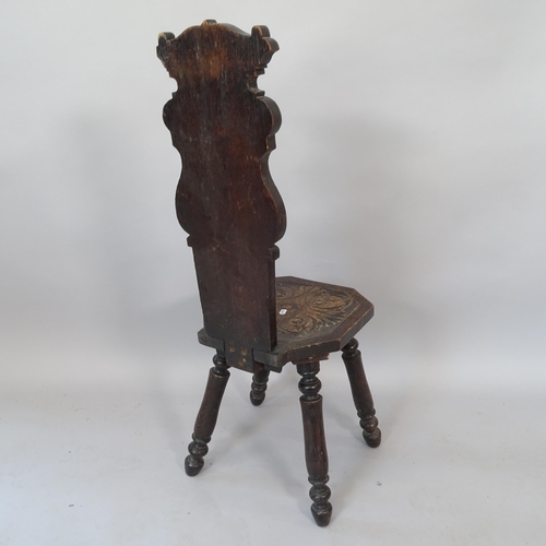 2068 - An Italian design oak hall chair, with carved back and seat