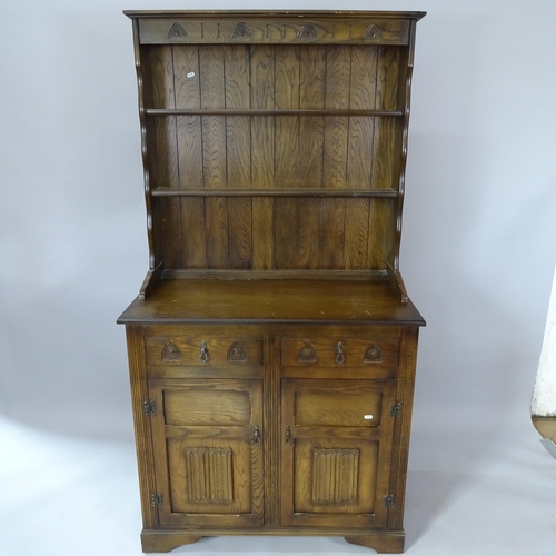 2075 - An oak 2-section dresser, with boarded open plate rack and carved panelled doors, 95cm x 188cm x 49c... 