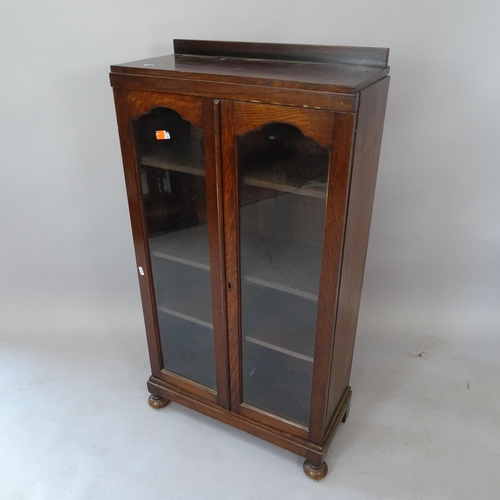 2105 - A 1930s oak bookcase, with 2 glazed doors and 3 adjustable shelves, 59cm x 112cm x 26cm