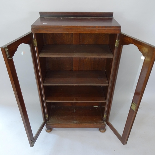 2105 - A 1930s oak bookcase, with 2 glazed doors and 3 adjustable shelves, 59cm x 112cm x 26cm