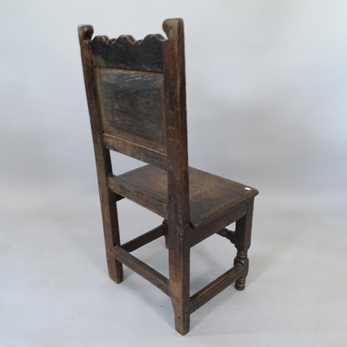 2110 - An 18th century oak hall chair with carved decoration