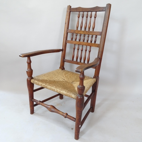 2121 - An Antique oak rush-seated open armchair