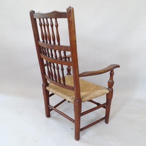 2121 - An Antique oak rush-seated open armchair