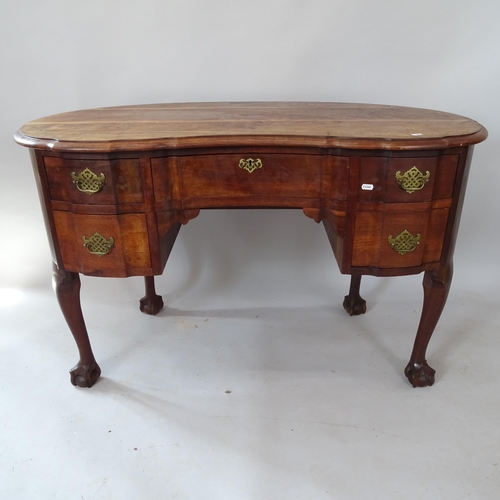 2131 - A reproduction oak kidney-shaped kneehole writing desk, on cabriole legs with claw and ball feet, 13... 