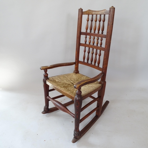 2135 - An oak and elm rush-seated spindle-back rocking chair