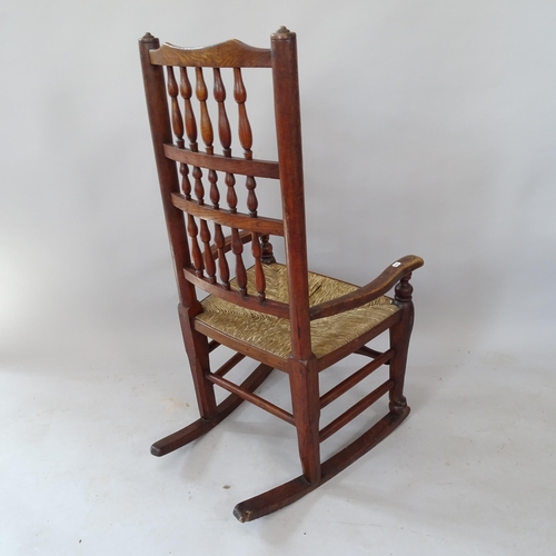 2135 - An oak and elm rush-seated spindle-back rocking chair