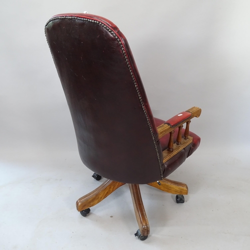 2187 - An early 20th century studded red leather upholstered button-back swivel desk chair