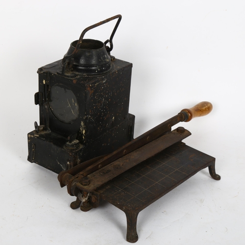 341 - A small black painted metal oil lantern, and a paper guillotine (2)